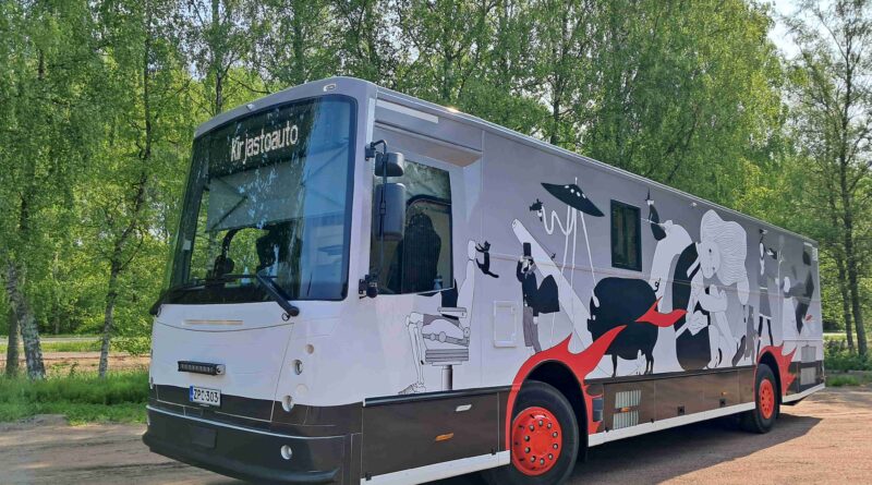 kirjastoauto pysäköitynä vihreiden puiden eteen